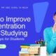 Female student focusing at her study desk with books, representing how to improve concentration while studying.